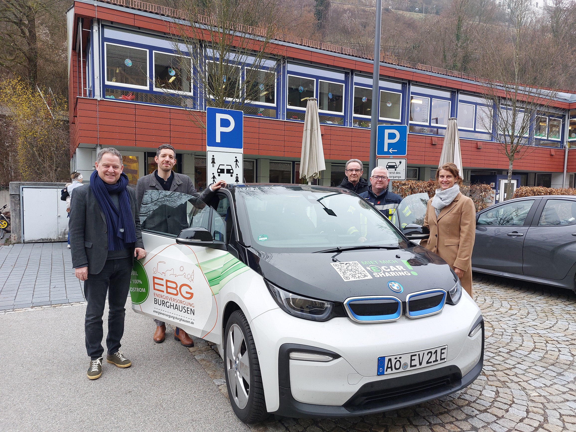 Fünf Personen stehen um ein CarSharing Fahrzeug der EBG in Burghausen und weihen dieses ein.