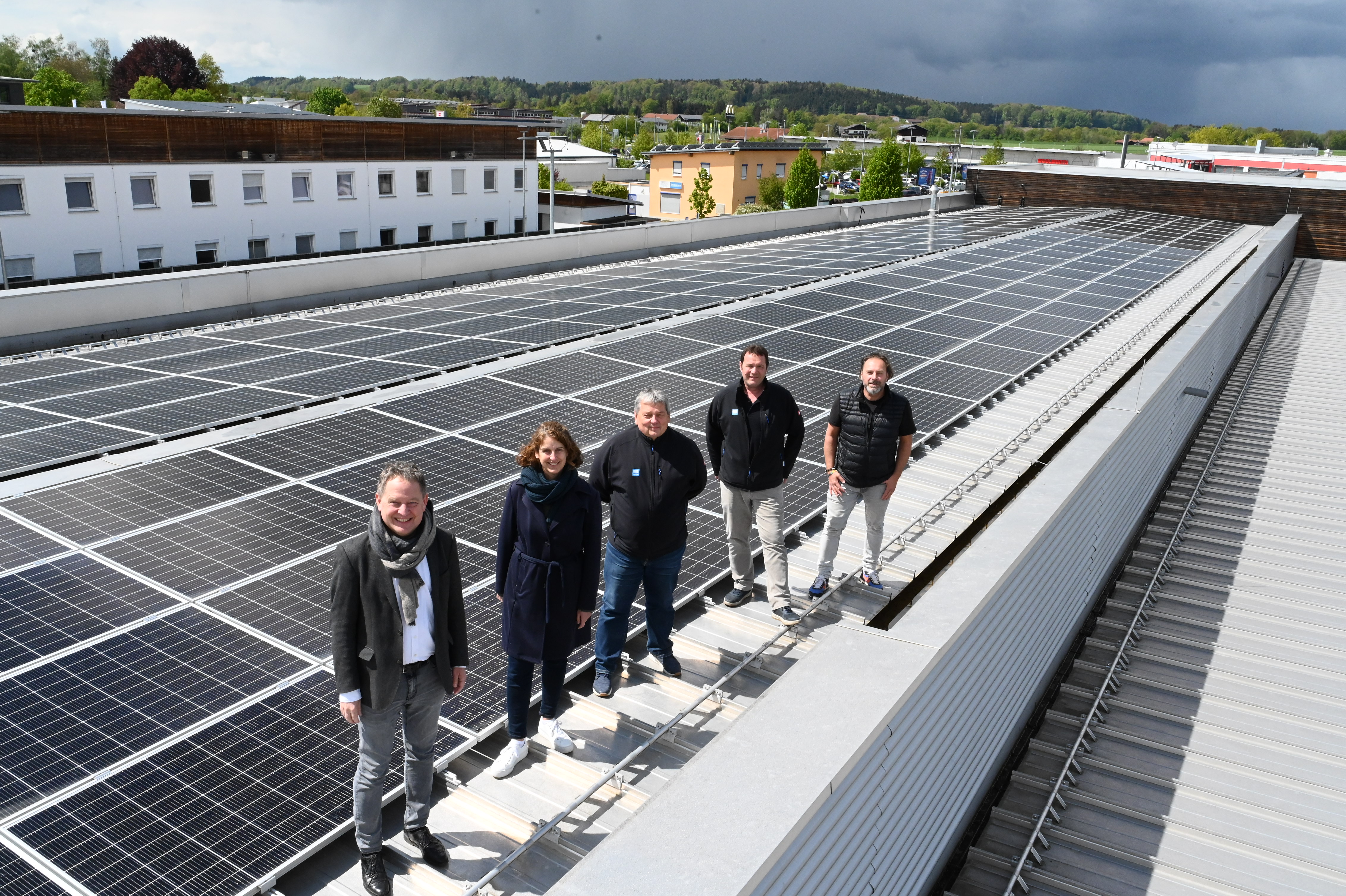 Fünf Personen stehen zur Einweihung neben der PV-Anlage auf dem Dach des Bauhofs in Burghausen.